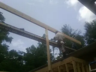 Carpenter setting a ridge beam over a new addition frame — Ice Dam Removal by Roofing Brothers in Tippecanoe