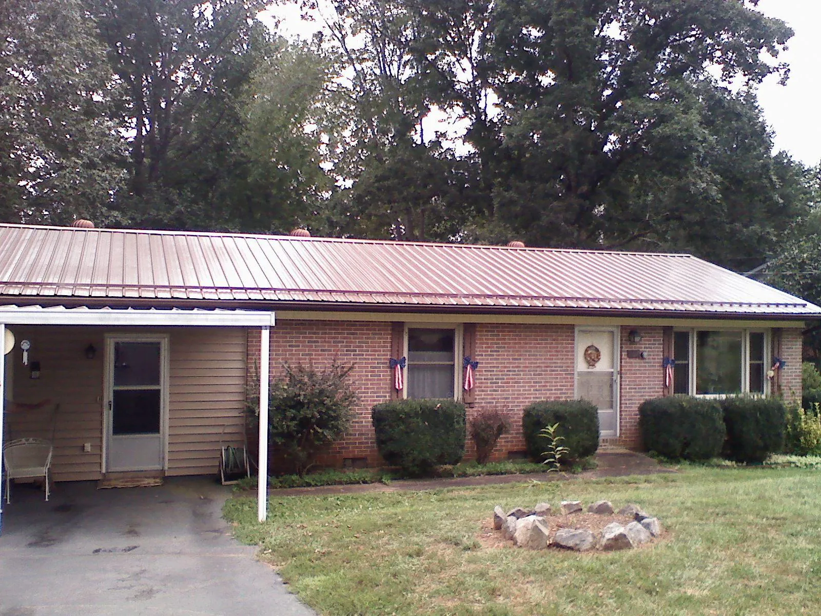 Bronze metal roof and carport on a brick ranch home — Roof Repair work by our crew in Tippecanoe